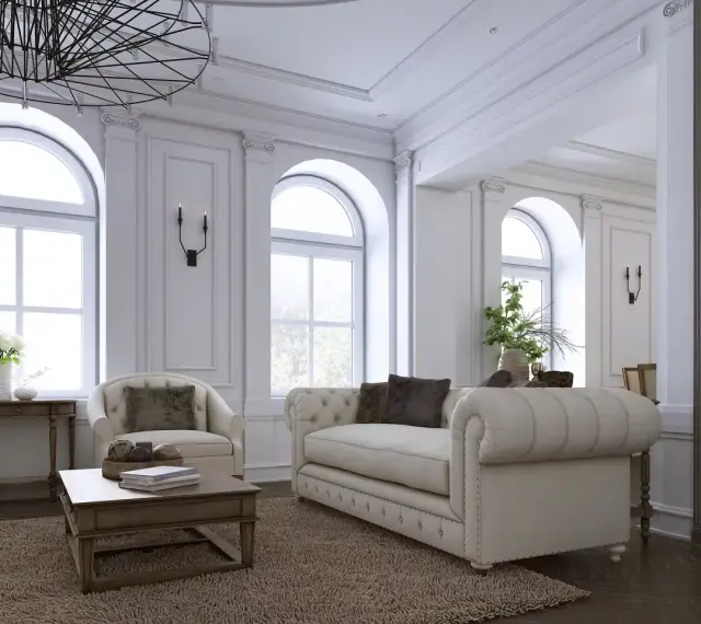 Elegancki salon z sofą, fotelem i książkami na półce.